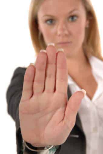 Blonde real estate lawyer in business clothing with hand up signaling STOP