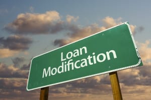 Loan Modification Green Road Sign with dramatic clouds and sky.