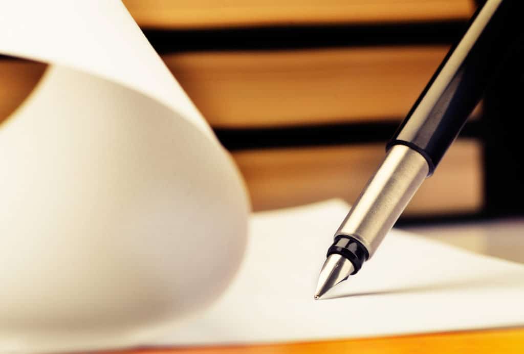 pen signing on paper drafting a contract - Inland Empire contract attorney