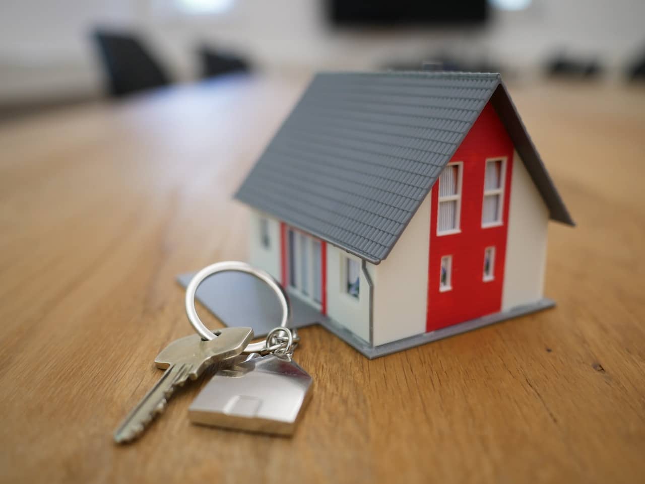 miniature house with key on a table, representing selling a house