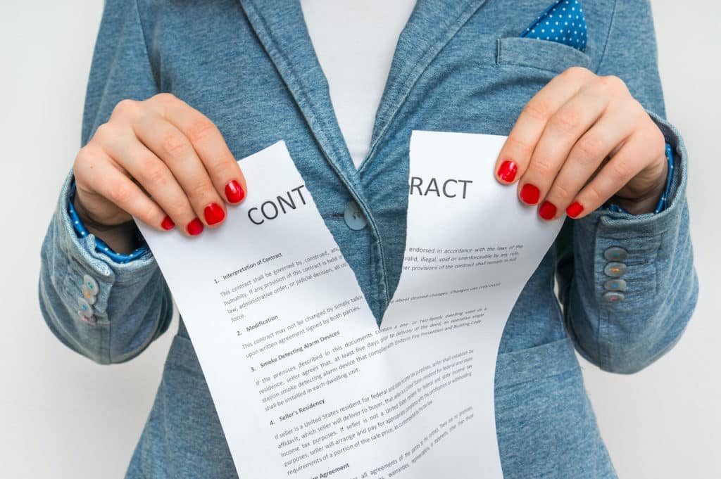 a woman with red fingernails rips a paper titled "contract"