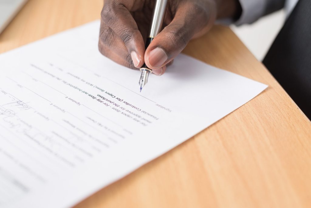 man signing housing contract