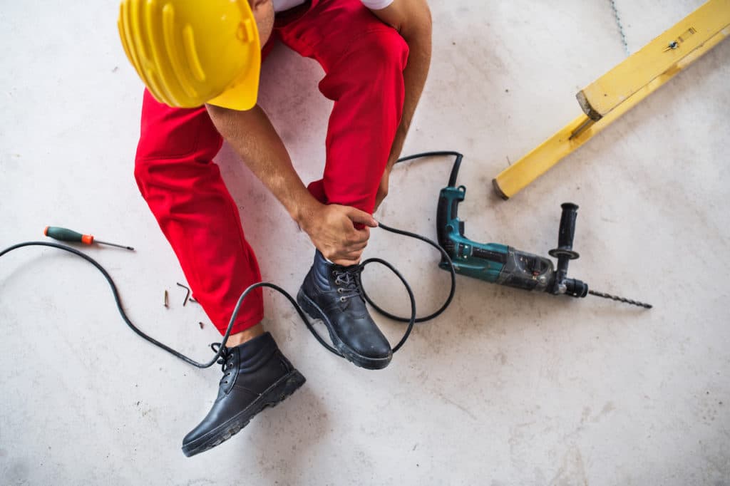 construction worker holding ankle - construction injury attorney