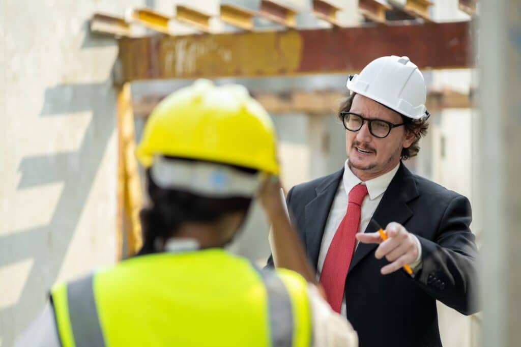 construction worker and lawyer discussing construction liens at construction site