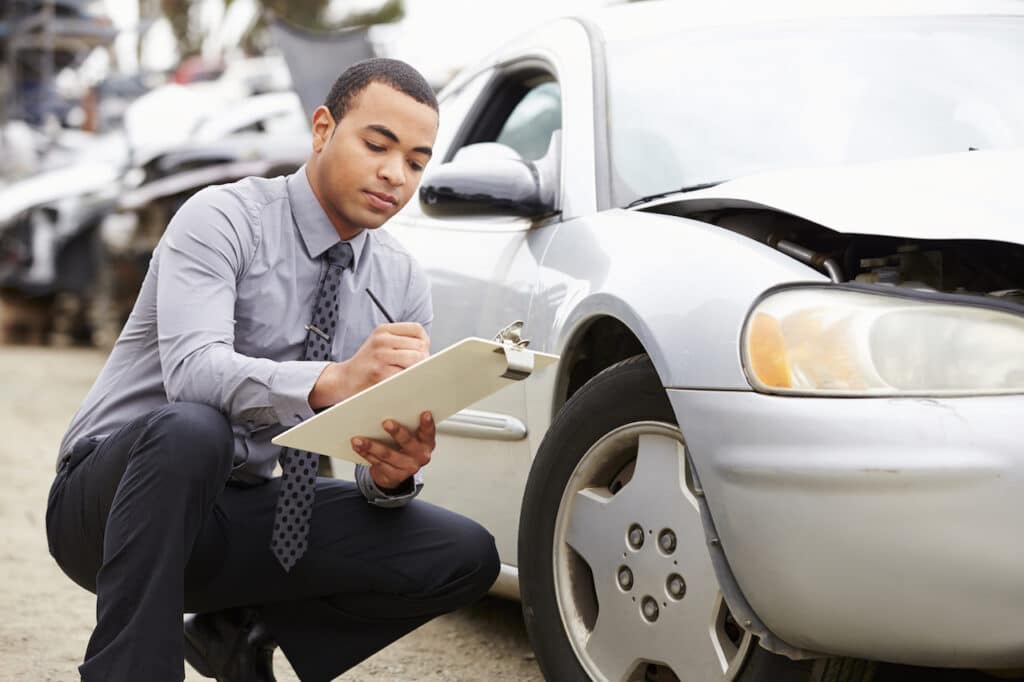 person inspecting car after car accident